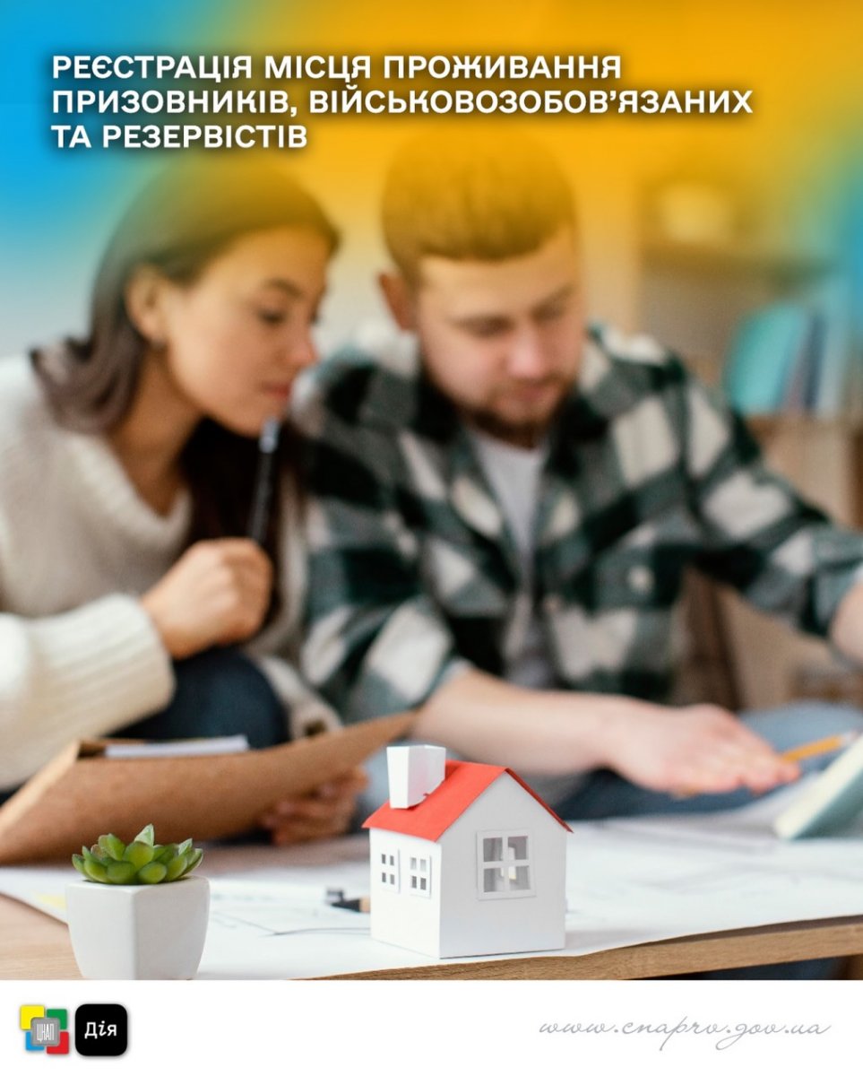 Чоловік та жінка розглядають документи, на передньому плані – макет будинку та кімнатна рослина.
